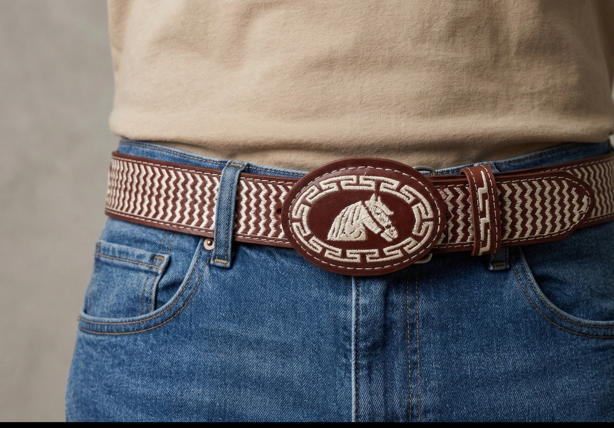 Embroidered western cowhide belt with oval horse buckle, worn by a man with jeans