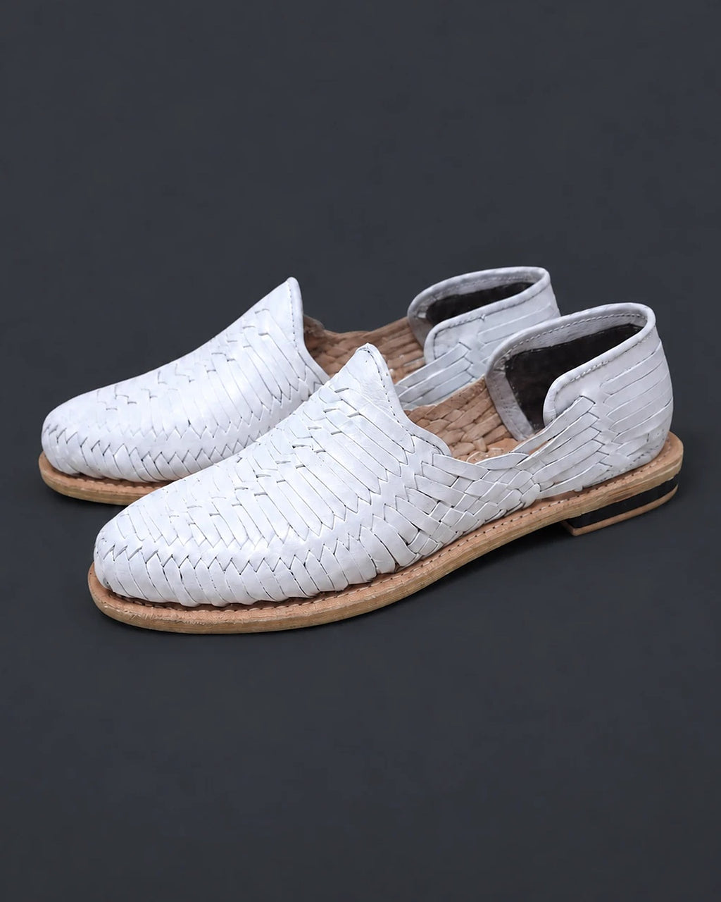 Pair of white leather closed toe huarache sandals for women, three-quarter view: diagonal weave, covered heel with dark lining and stitched leather sole