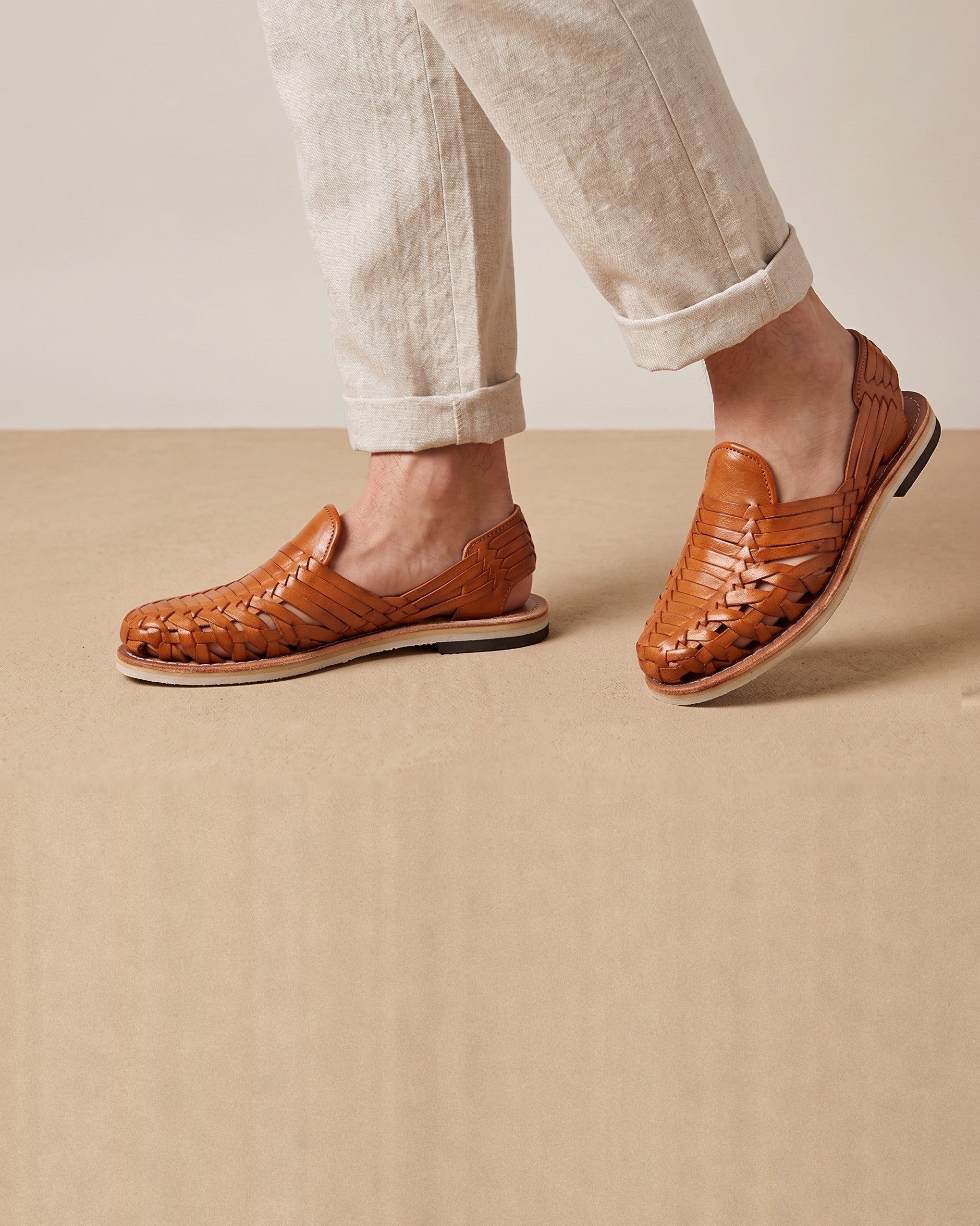 Men's brown skeleton-weave leather huaraches worn with linen trousers