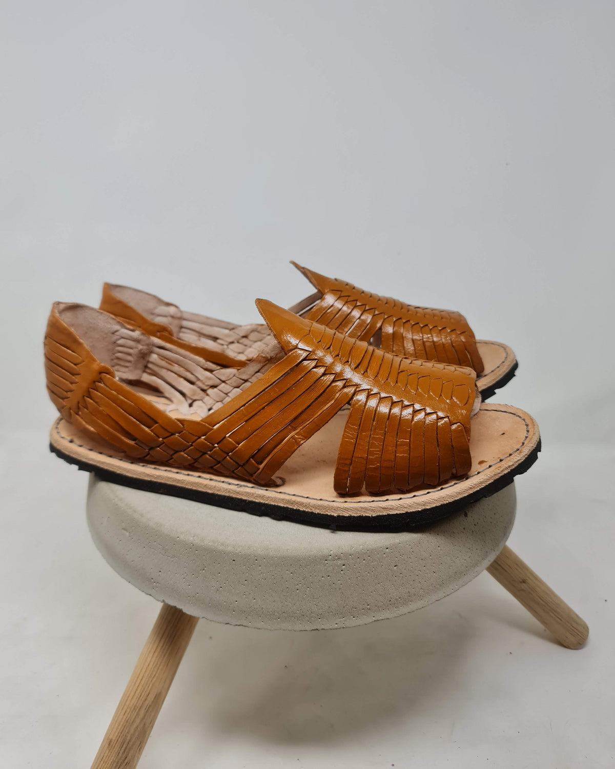 Open-toe honey brown huarache sandals for men in profile, showing the black rubber sole