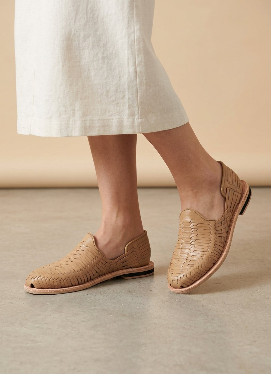 Women's taupe huarache sandals styled with light linen trousers, AI-generated lifestyle image