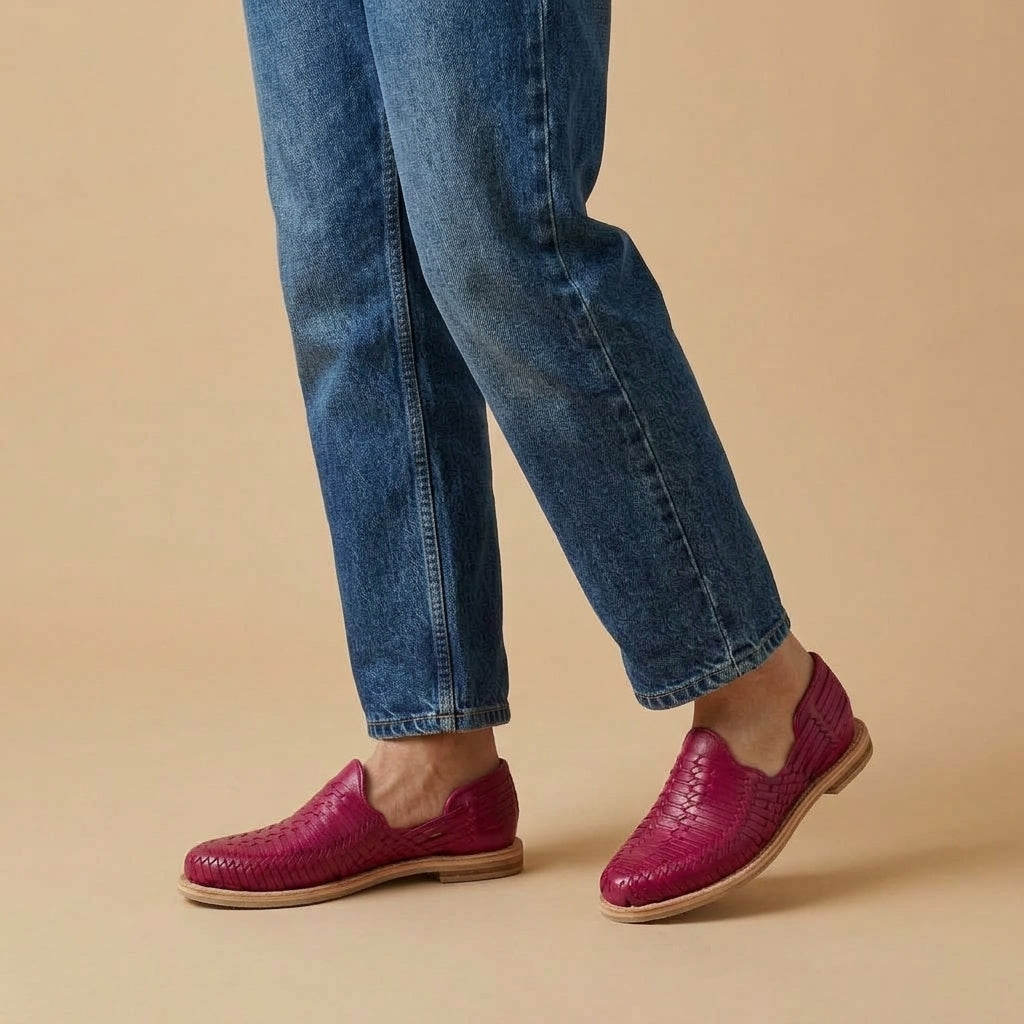 Huaraches rosa mexicano para mujer de piel tejida a mano, cerrados y con suela de cuero, puestos con jeans azules al tobillo; imagen de estilo generada por IA