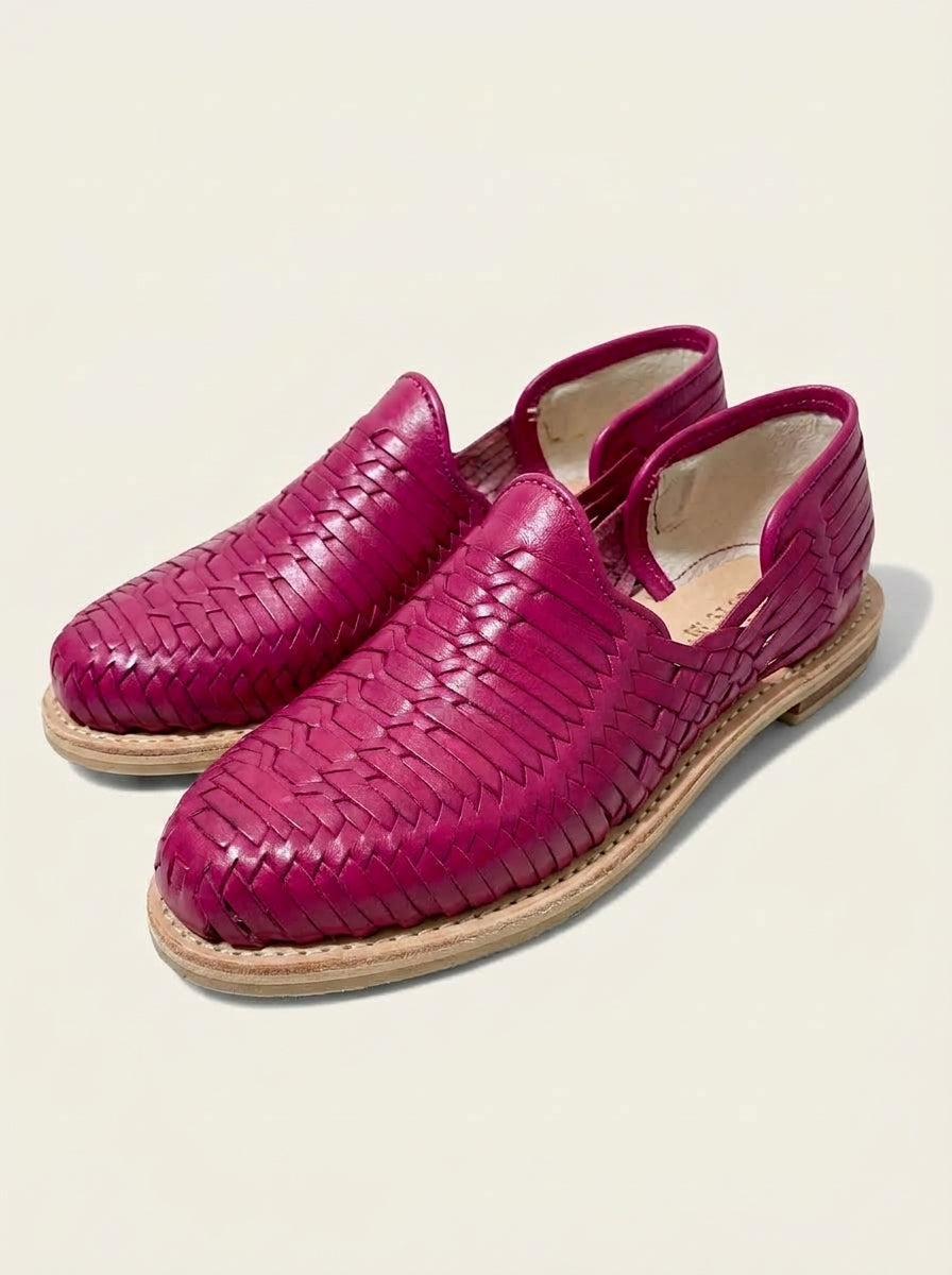 Par de huaraches rosas para mujer, cerrados de piel: tejido en diagonal, talón cubierto y suela de cuero cosida; imagen del producto generada con IA