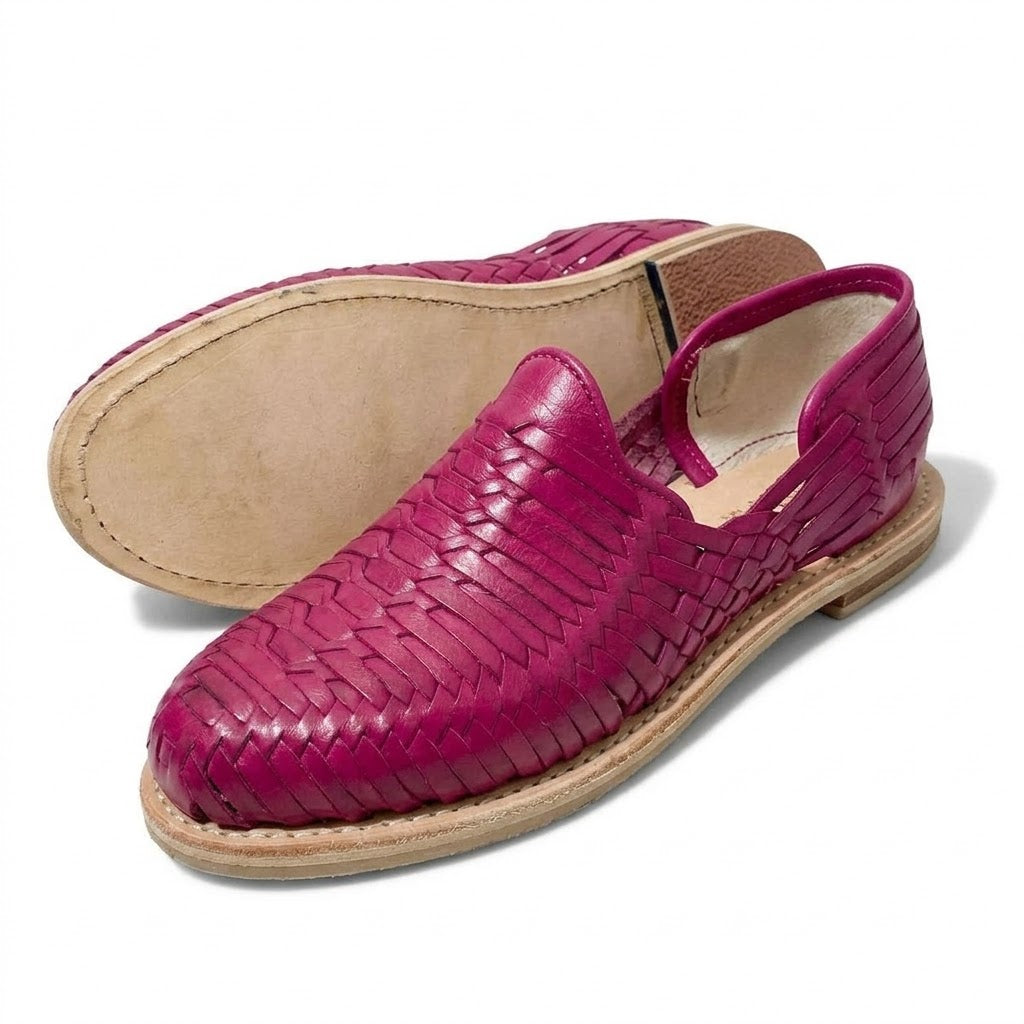 Suela de cuero natural cosida al canto y tacón bajo apilado de unos huaraches rosas para mujer, cerrados de piel; imagen del producto generada con IA