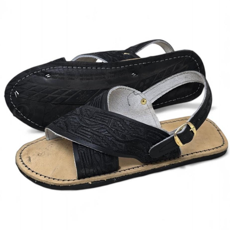Black on black embroidered huarache sandals, one turned over to show the tire sole