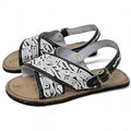 Black and white embroidered huarache sandals for men with cross straps and a gold-tone back strap buckle