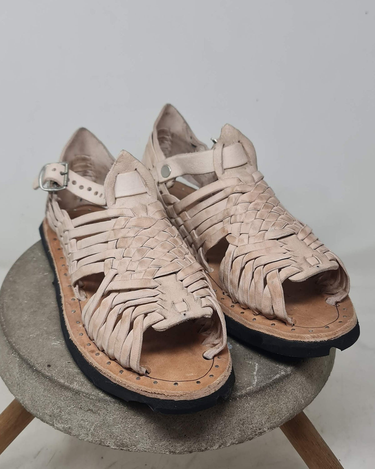 Mens open toe huarache sandals in undyed beige leather, front view with the wide leather band over the toes