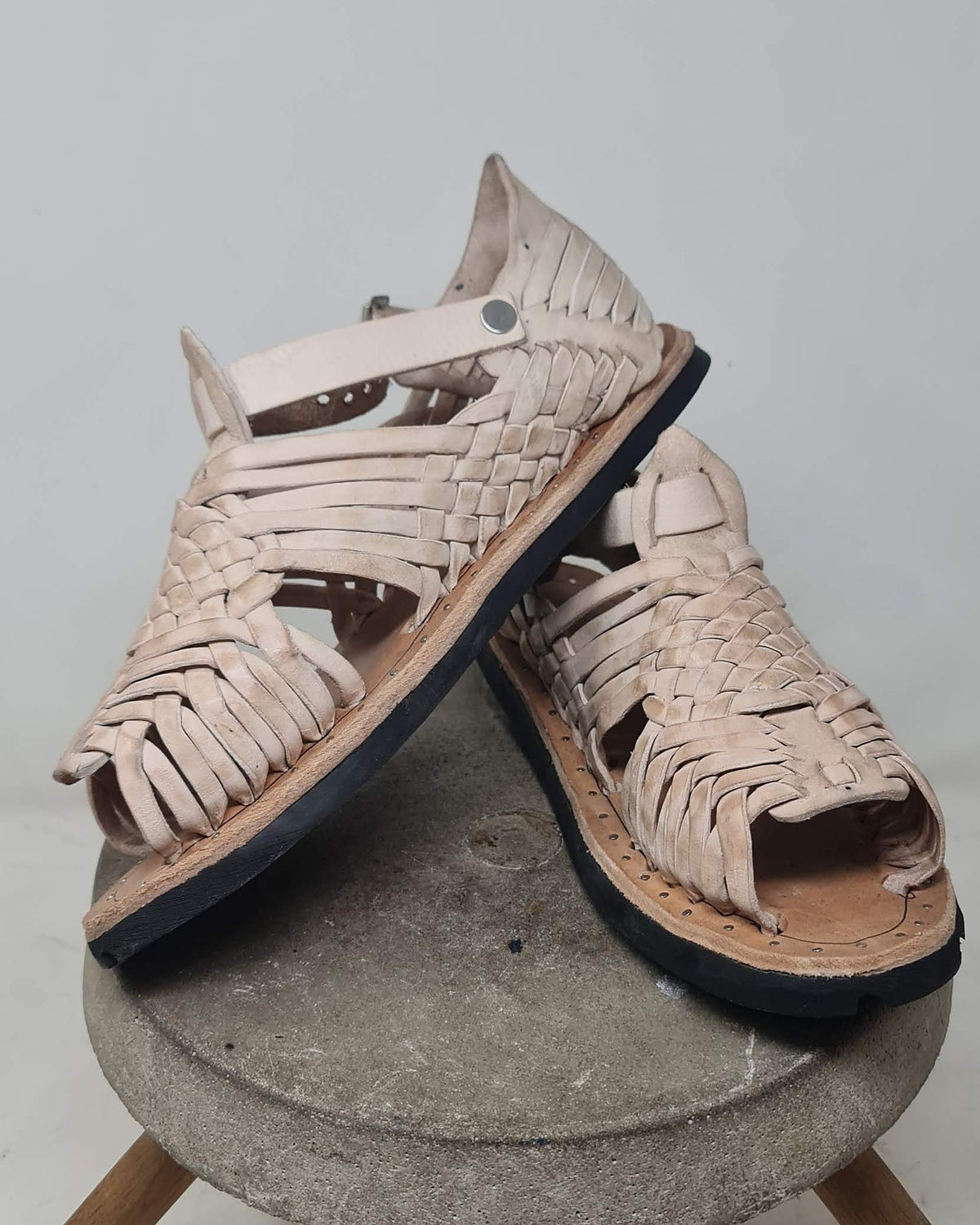 Stacked pair of beige huarache sandals: pachuco woven leather, riveted ankle strap and natural vaqueta insole