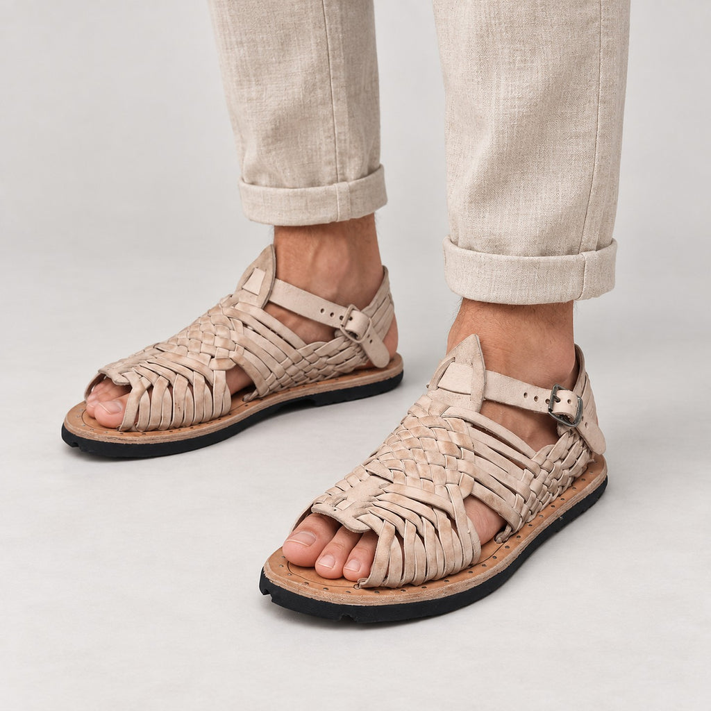 Man in beige linen pants wearing men's pachuco huarache sandals in natural leather with ankle strap and tire soles