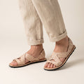 Men's open toe woven leather huarache sandals, natural leather, rubber sole, worn standing, linen pants with rolled cuffs