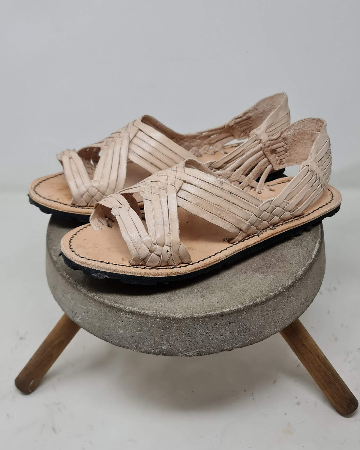 Men's open toe woven leather huarache sandals, natural leather, rubber sole, three-quarter view showing the heel counters