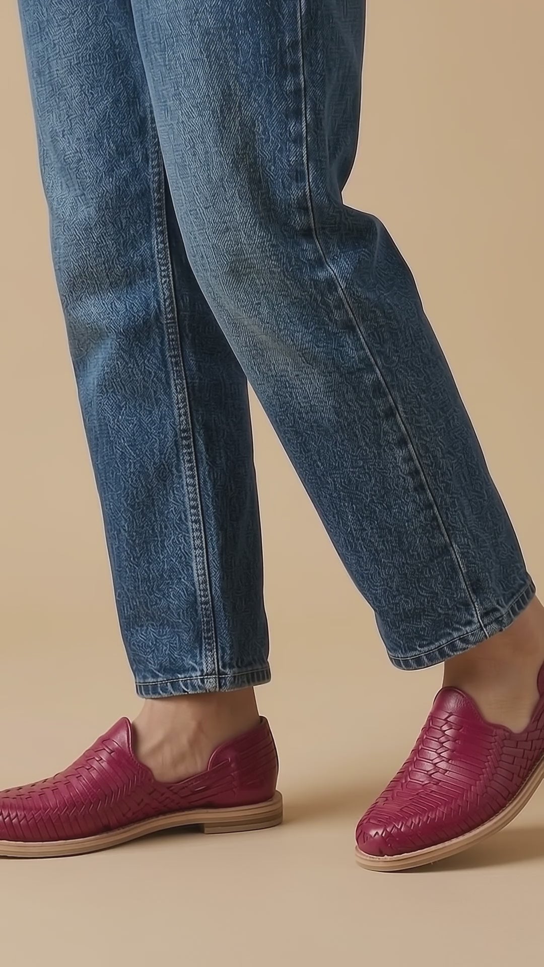 Huaraches rosa mexicano para mujer, cerrados y de piel tejida, puestos con jeans azules al caminar sobre fondo beige; video generado con IA