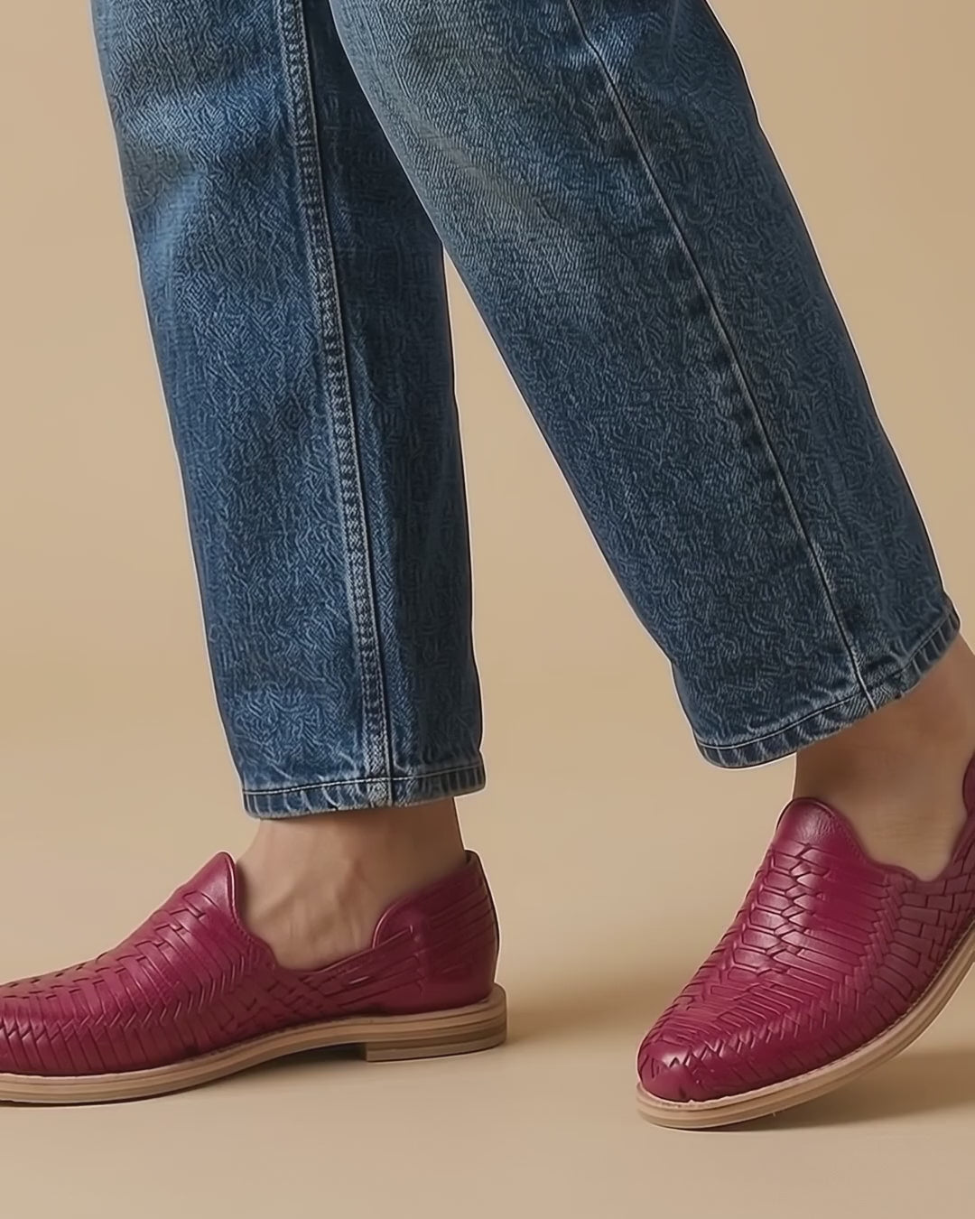 Huaraches rosa mexicano para mujer, cerrados y de piel tejida, puestos con jeans azules al caminar sobre fondo beige; video generado con IA