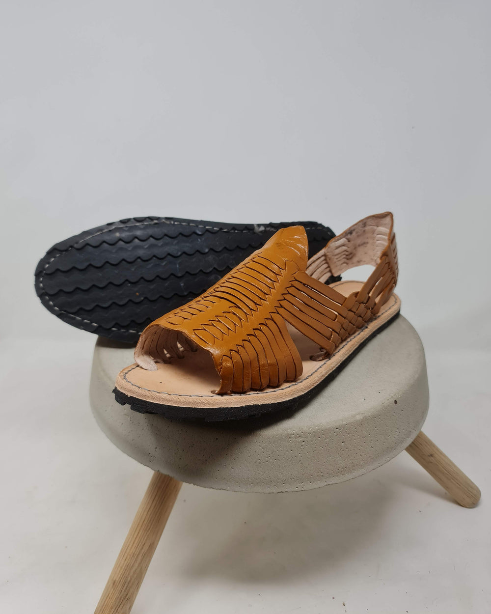 Leather huarache with a non-slip rubber sole on a stool